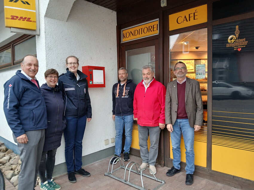 Vor dem neuen „Defi“ Standort v.l.: Klaus Rupp (DRK Spielberg), Dr. Mirjam Güldensupp (stellvertretende Ortsvorsteherin), Dr. Stefanie Ochs (DRK), Daniel Behrenz (DRK), Richard Nussbaumer und Joachim Karcher (Ortsvorsteher). Foto: Gemeinde Karlsbad