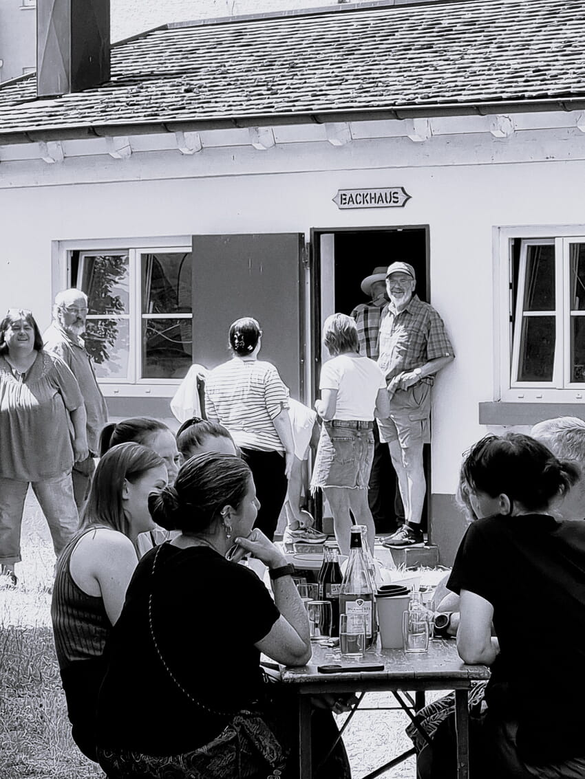 Gut gelaunt, warten alle auf das fertige Brot im Museumshof