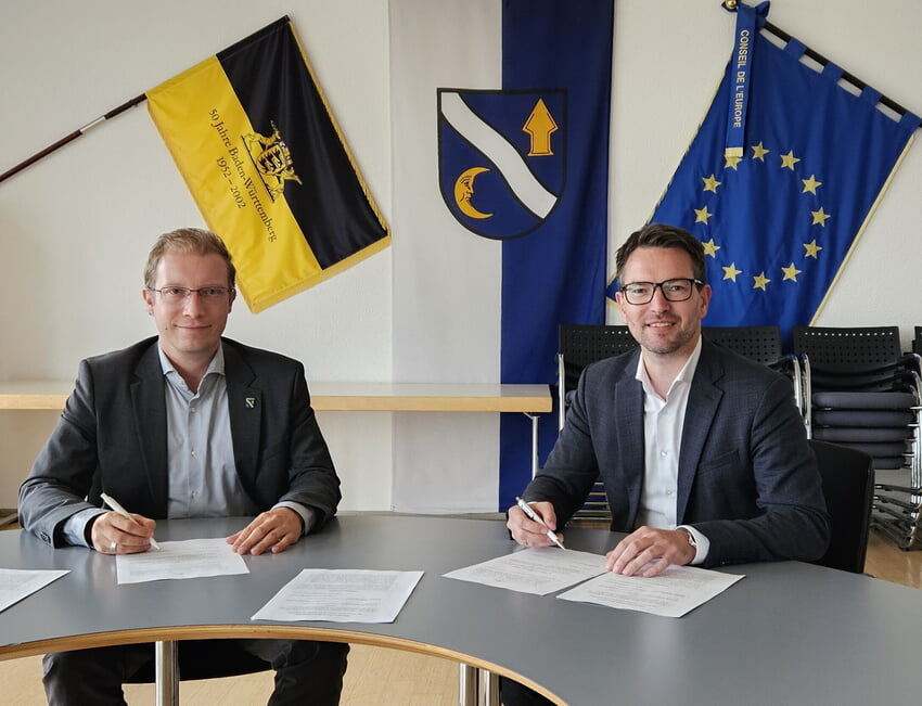 V.l. Die Bürgermeister Christian Stalf - Waldbronn - und Björn Kornmüller unterzeichnen die Vereinbarung zur Kostenbeteiligung am Schulzentrum Karlsbad. Foto: Gemeinde Waldbronn