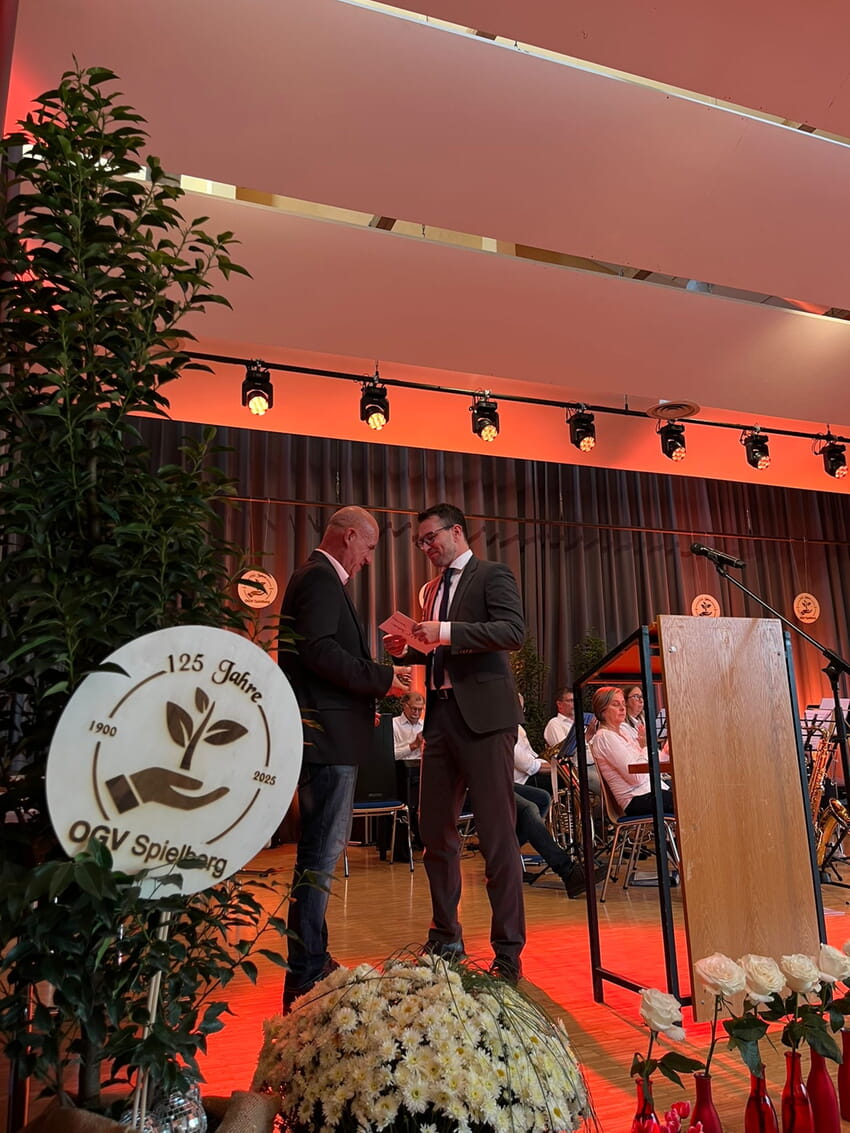 V.r. Bürgermeister Björn Kornmüller übergibt dem Vorstandsvorsitzenden des OGV Spielberg Uwe Kraft die Jubiläumsgabe der Gemeinde Karlsbad. Foto: OGV Spielberg