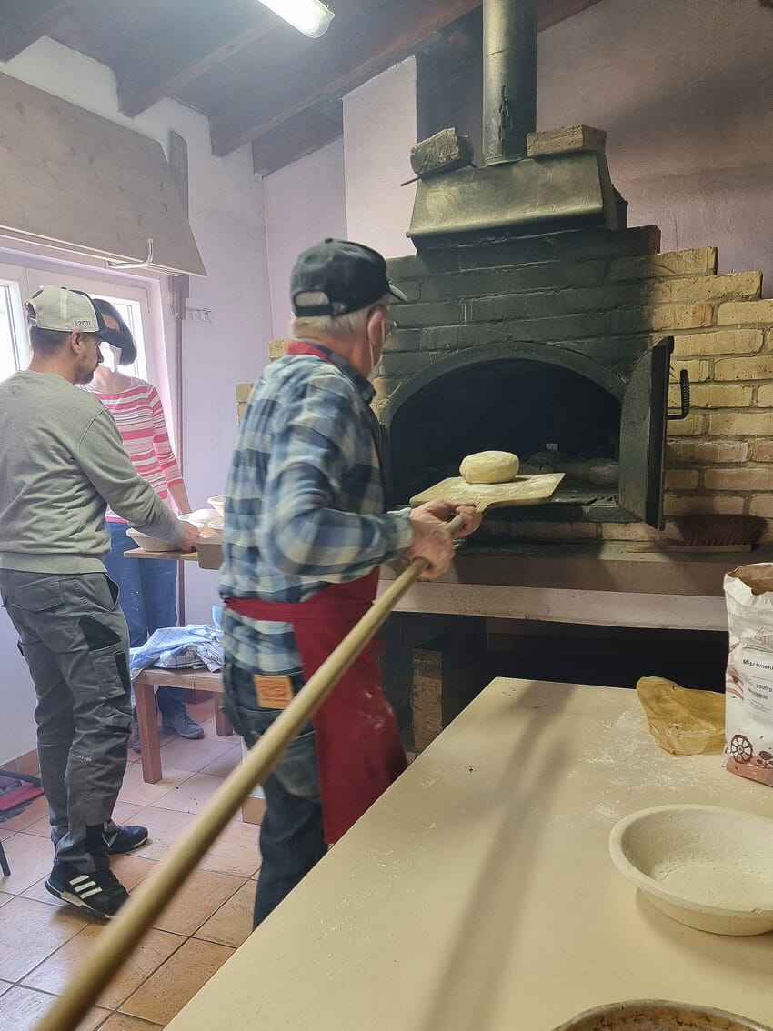 Die Teiglinge kommen in den vorgeheizten Holzofen.