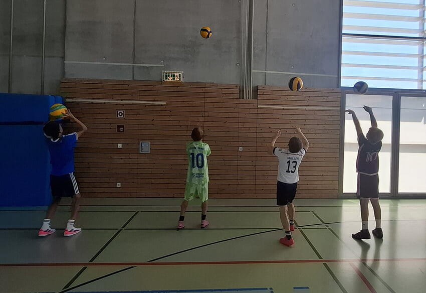 Bevor die Kinder den Volleyball über das Netz spielten, sollten sie versuchen, den Ball in eine bestimmte Zone gegen die Wand zu pritschen.