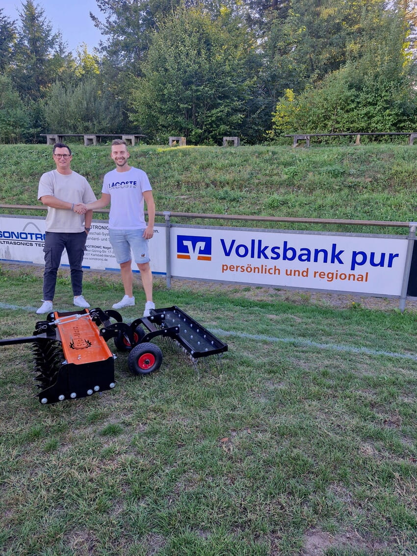 Kai Hemminger, Filialleiter der Volksbank pur, bei der symbolischen &Uuml;bergabe des neuen Rasenl&uuml;fters an Dominik L&ouml;rch vom VfR Ittersbach.